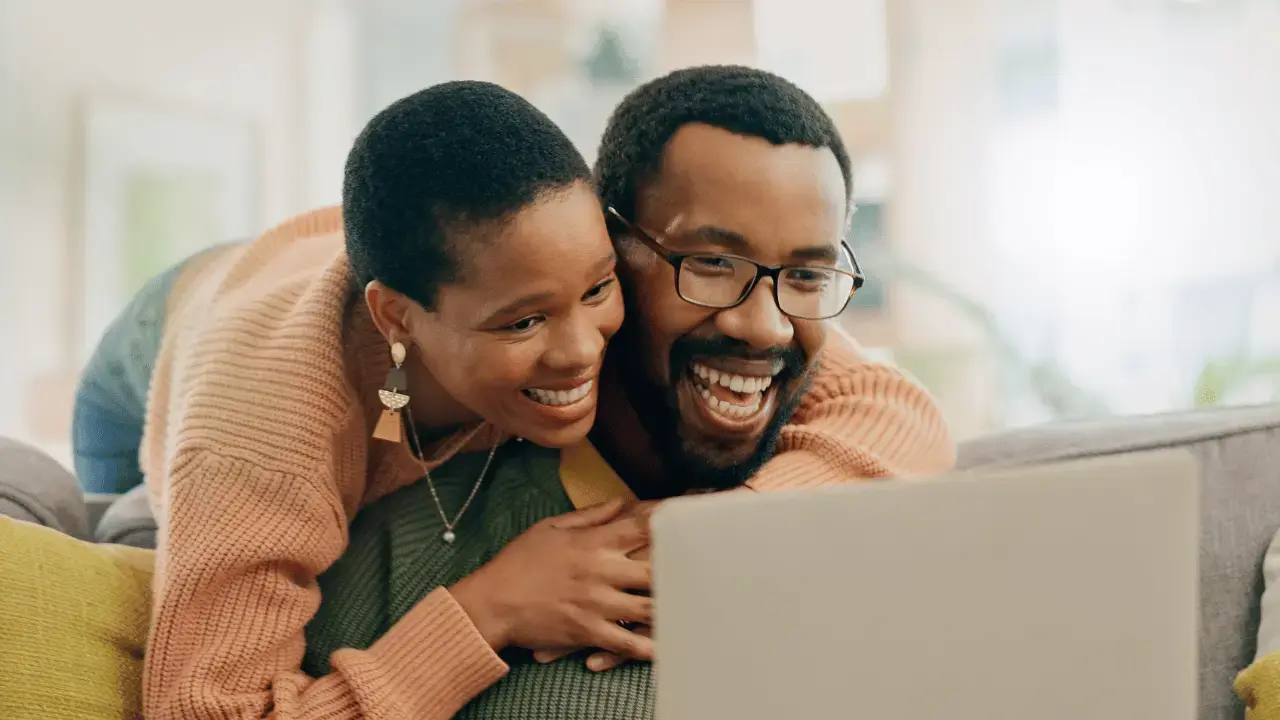 Foto de um casal sorrindo em frente a um notebook: A integração como base do sucesso