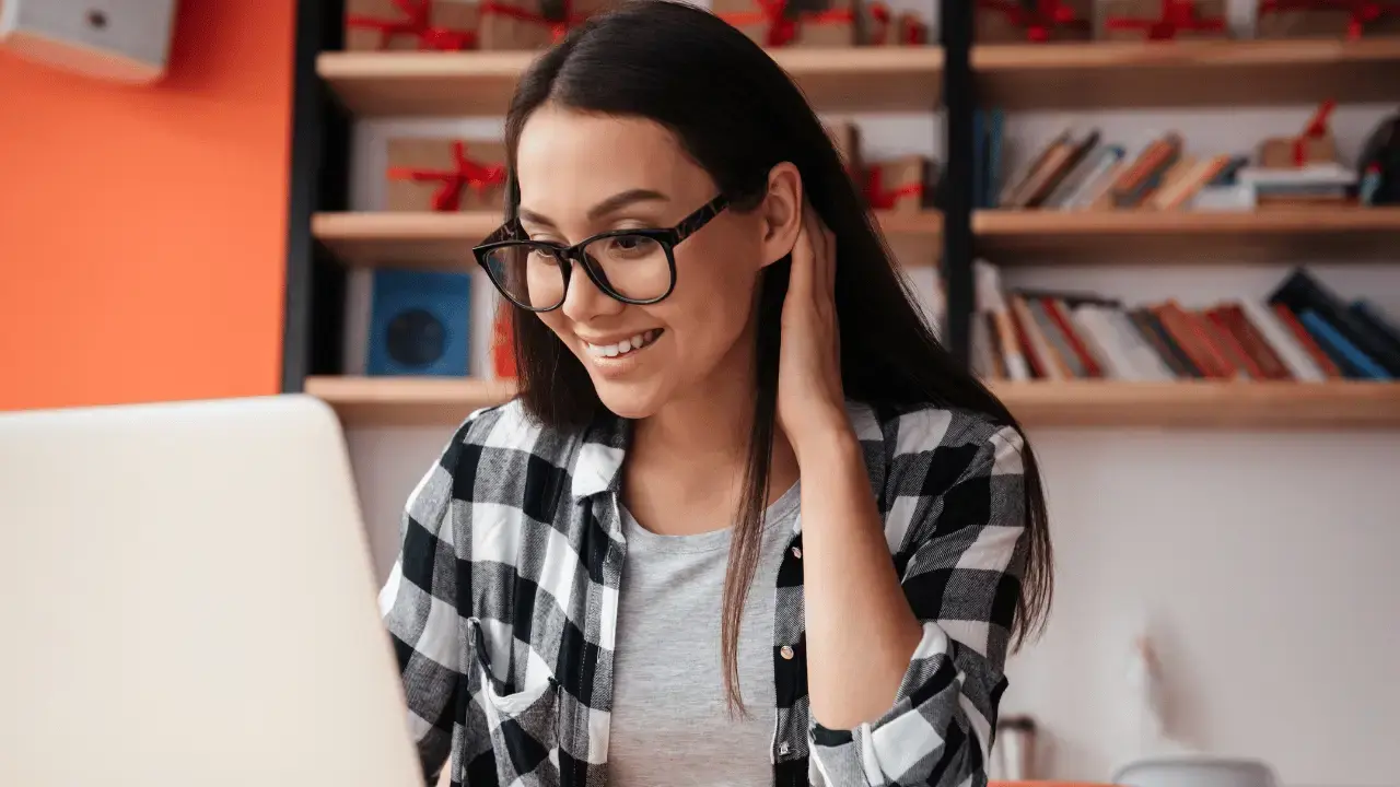 Foto de uma mulher mexendo no seu computador: Como a telefonia em nuvem funciona?